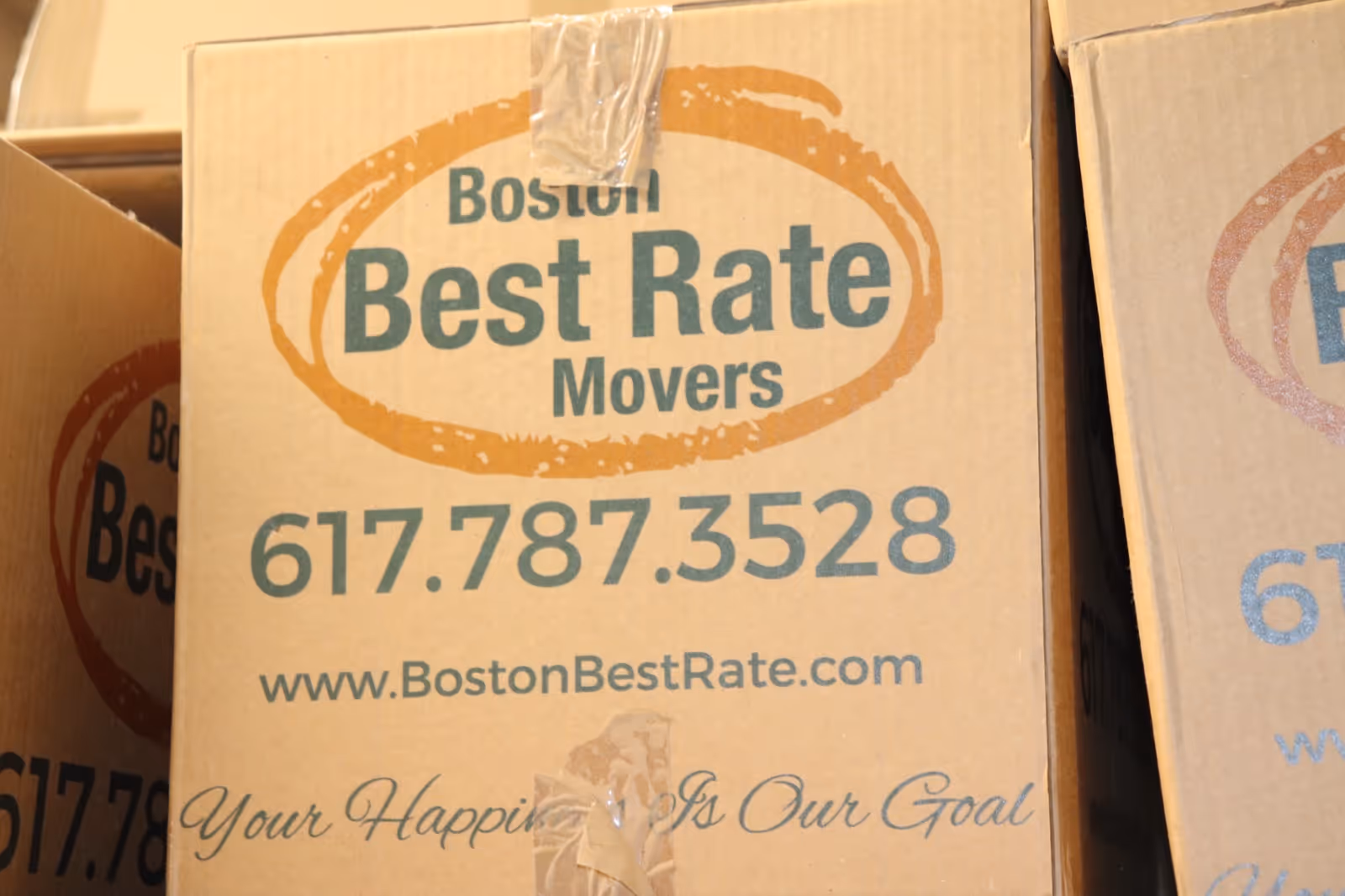 Boston Best Rate Movers box logo close-up showing Your Happiness Is Our Goal