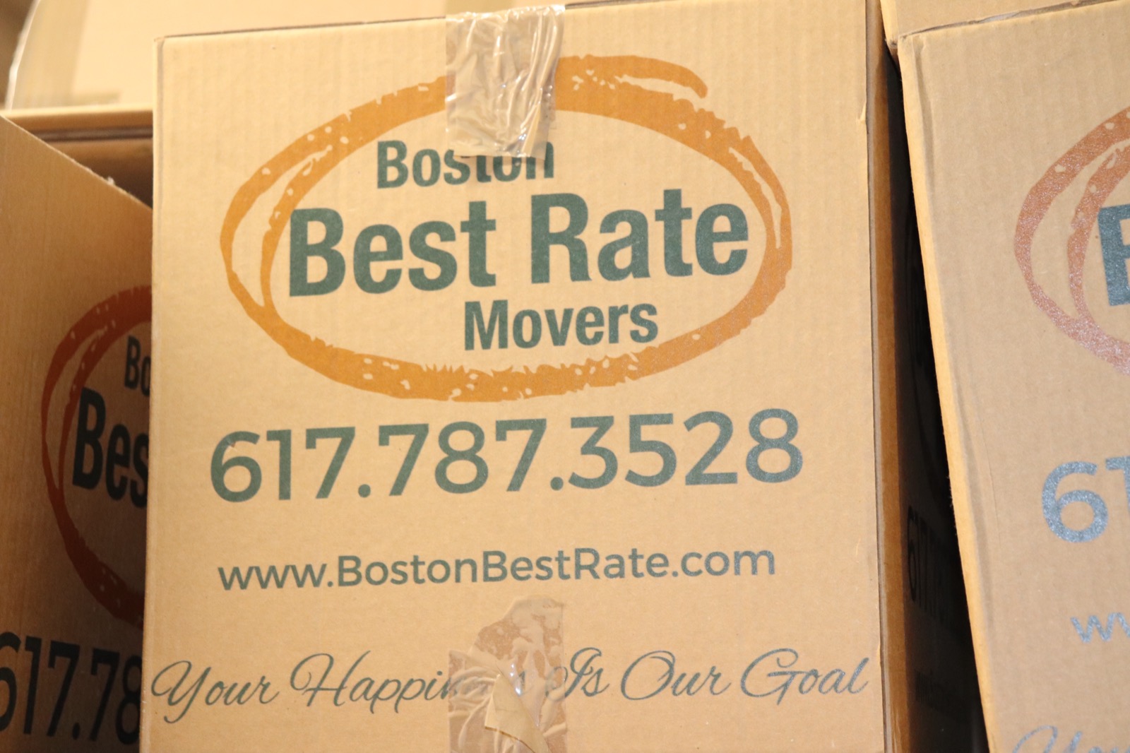 Boston Best Rate Movers box logo close-up showing Your Happiness Is Our Goal