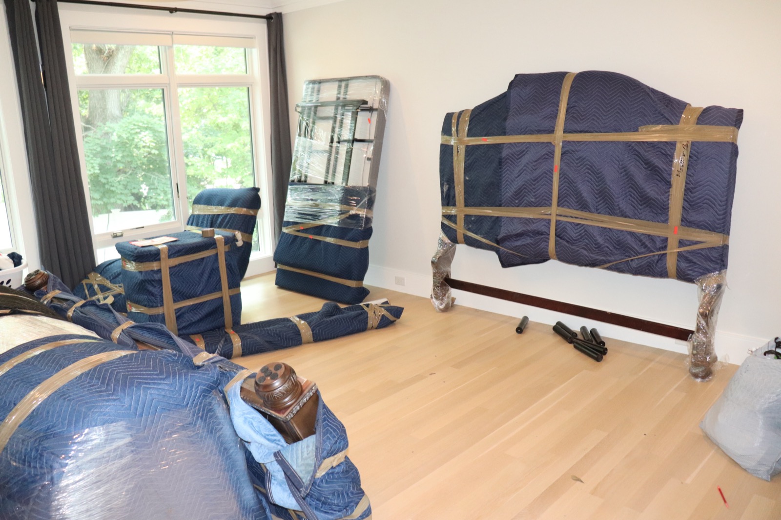 Living room furniture fully wrapped in moving blankets ready for transport