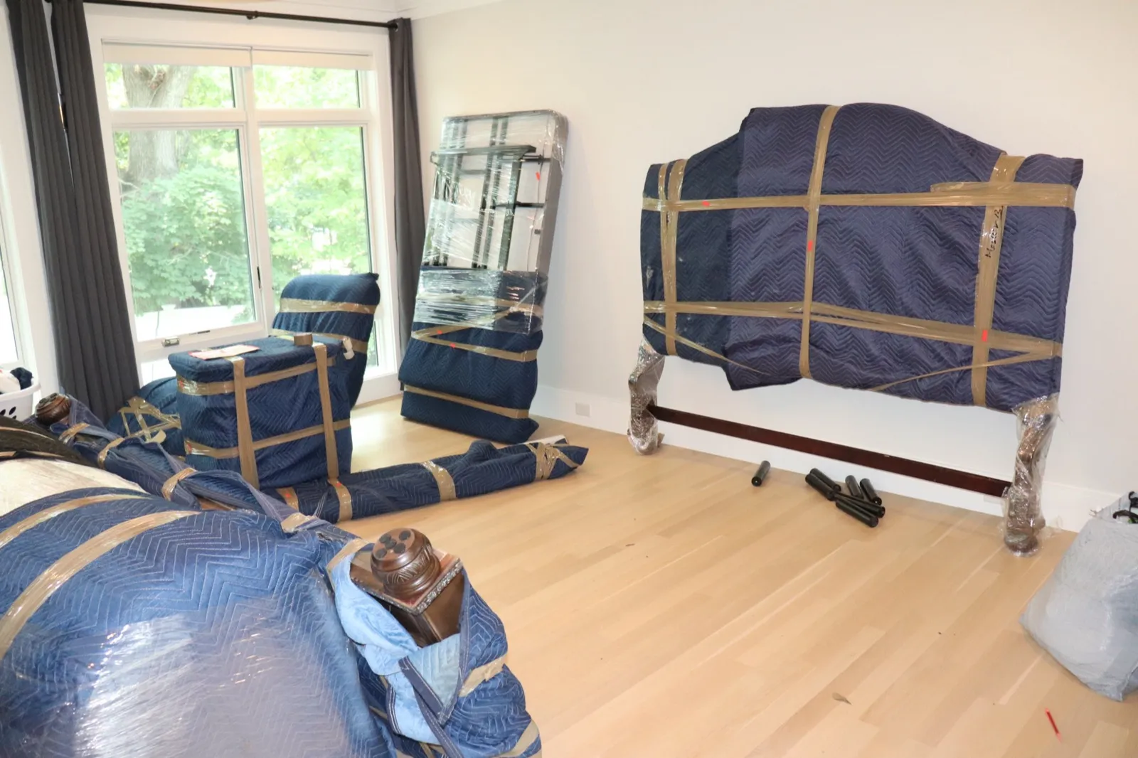 Living room furniture fully wrapped in moving blankets ready for transport