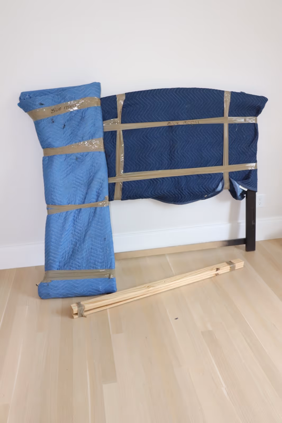 Bed frame carefully wrapped in protective moving blankets for safe transport