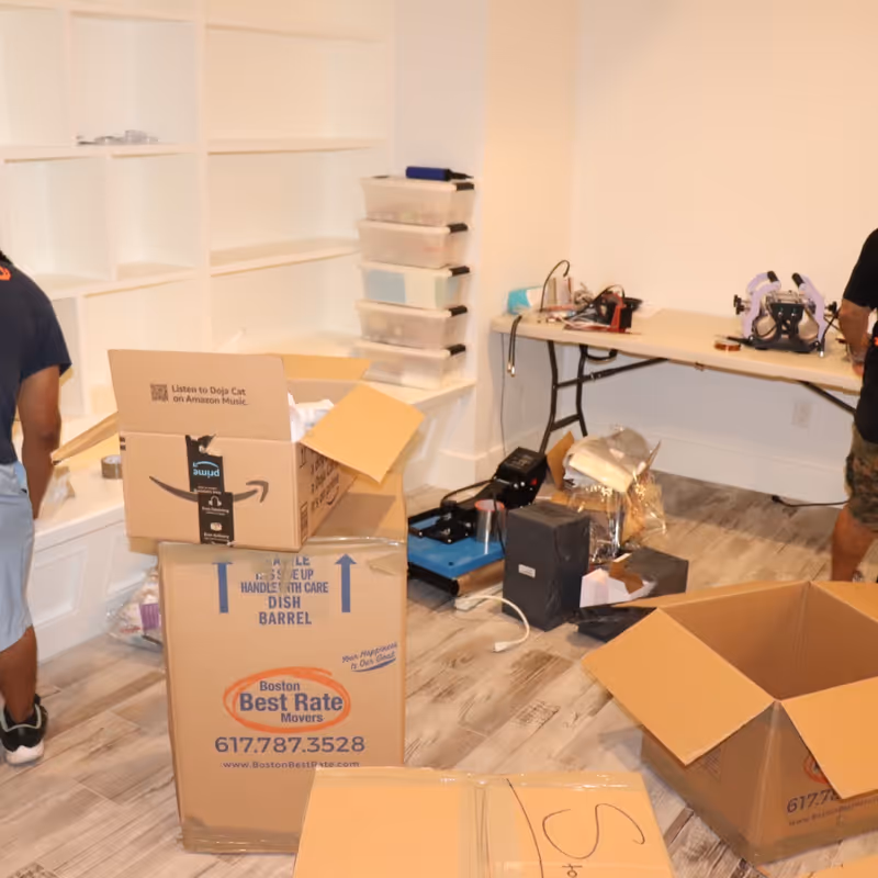 Two Boston Best Rate Movers crew members packing and organizing on the job
