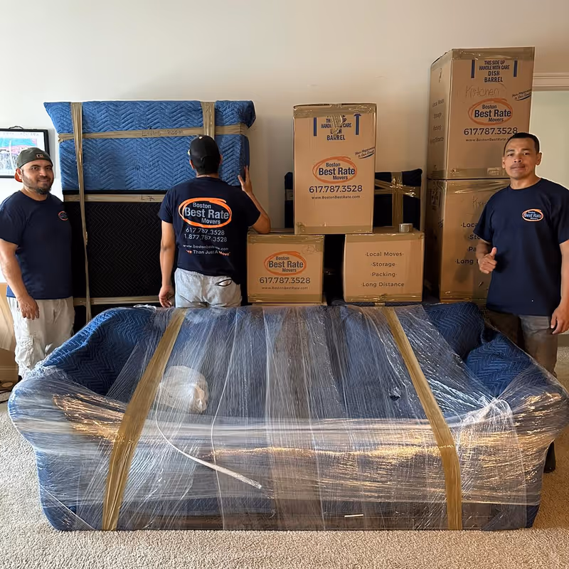 Three Boston Best Rate Movers crew members with packed furniture