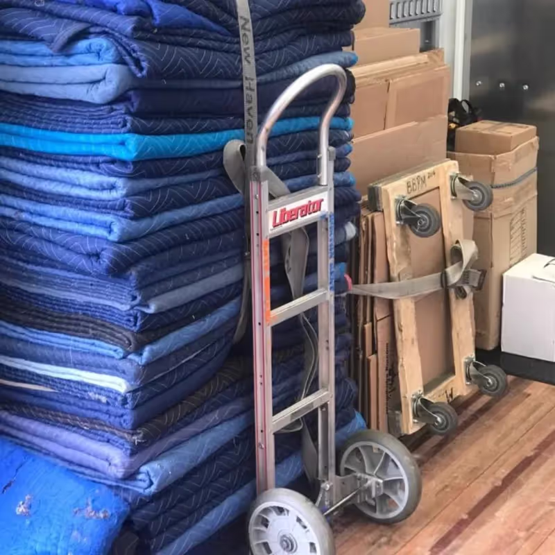 Boston mover carefully transporting a large item down stairs