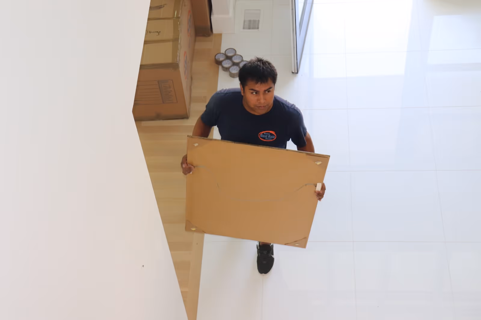 Boston Best Rate Movers crew member carefully carrying items downstairs