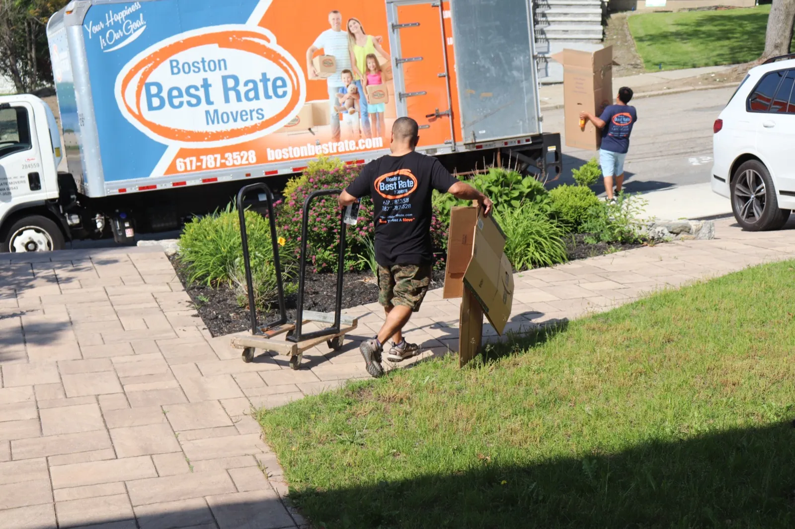 Boston Best Rate Movers crew member with dolly and truck in background