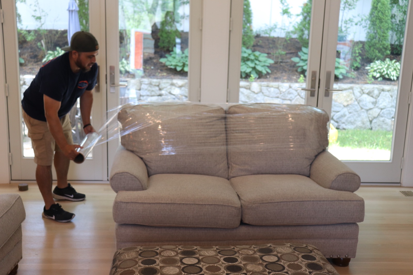 Boston Best Rate Movers crew member wrapping a sofa for protection