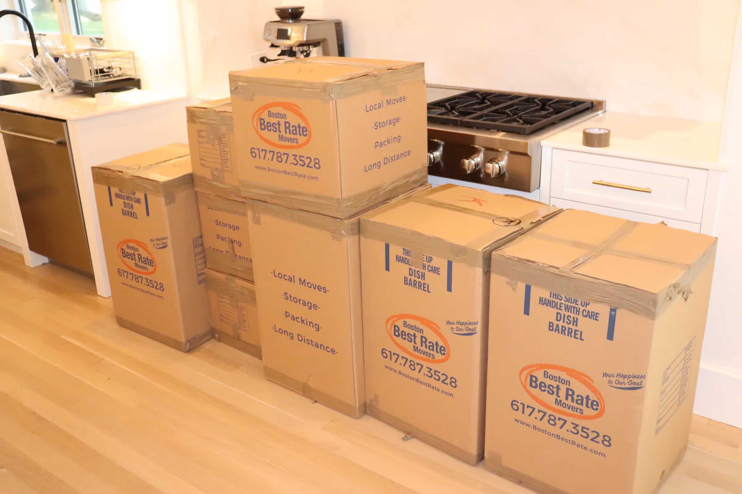 Mover stacking cardboard boxes labeled Boston Best Rate Movers inside a moving truck